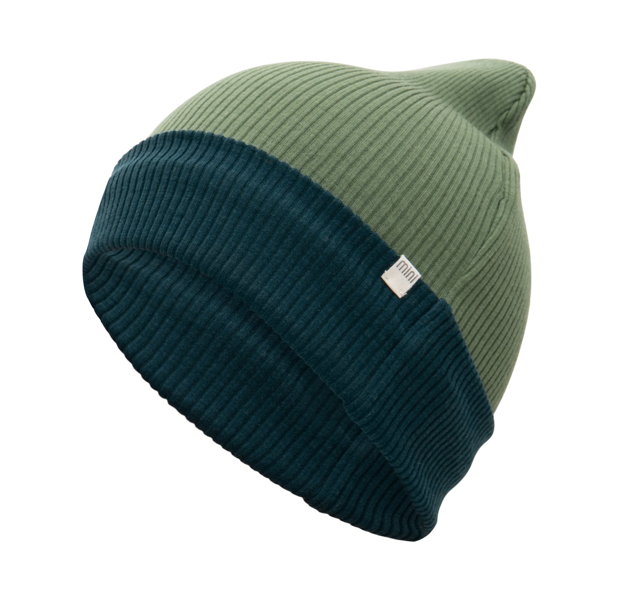 „Minimalistische Beanie-Mütze Arvid Contrast in Grün aus doppellagiger Merino-Wolle von minimalisma, liegend auf hellem Untergrund“