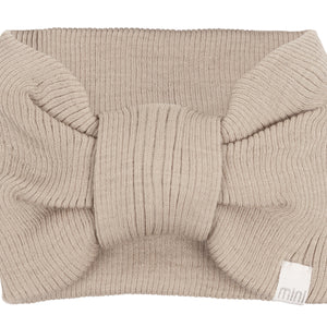 „minimalisma Stirnband ‚Alba‘ in Beige – geripptes Kinder-Stirnband aus Merinowolle, flach liegend auf hellem Hintergrund“