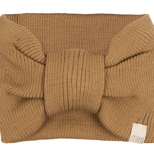 „minimalisma Stirnband ‚Alba‘ in Beige – geripptes Kinder-Stirnband aus Merinowolle, flach liegend auf hellem Hintergrund“