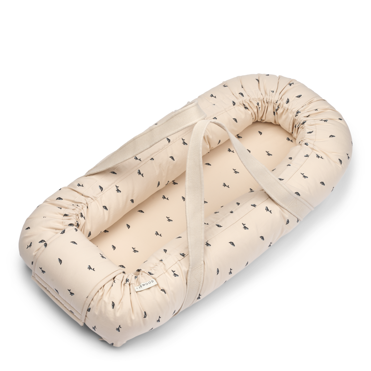 Liewood Babynest „Gro Pile“ in der Farbe Sandy mit Mini Whale-Muster – kuscheliges Babynest mit erhöhtem Rand und weichem Fleece.