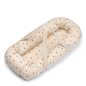 Liewood Babynest „Gro Pile“ in der Farbe Sandy mit Mini Whale-Muster – kuscheliges Babynest mit erhöhtem Rand und weichem Fleece.
