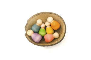 Grapat Baby & Nins mit sechs kleinen Nins-Figuren in sanften Farben und einer natürlichen Kokosnussschale als vielseitiges Spielelement.