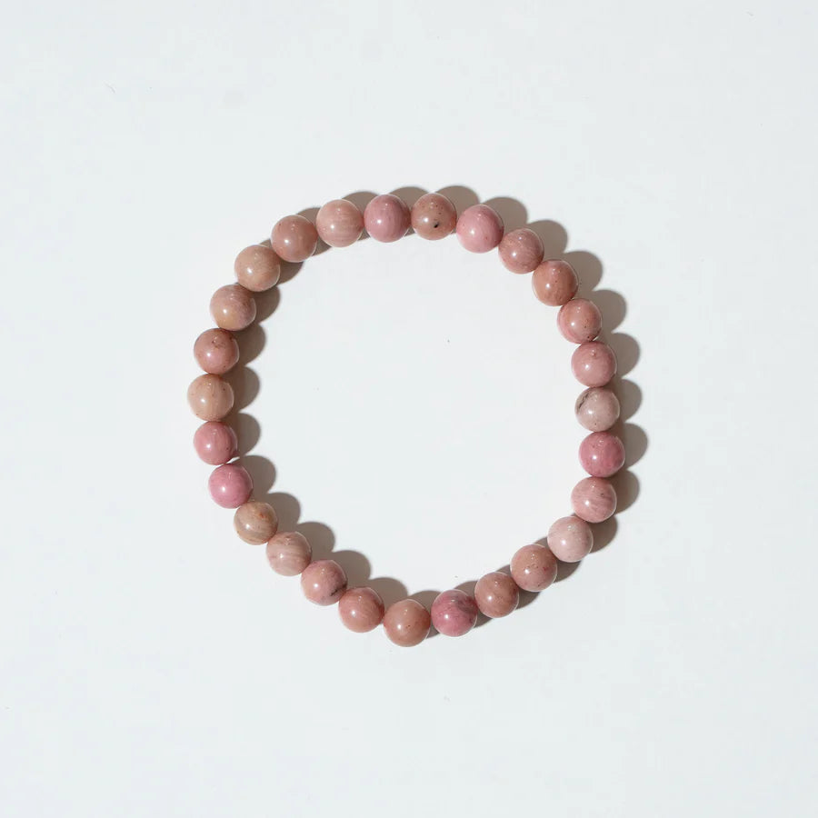 Armkette „Berry“ von Nirrimis aus rosafarbenen Rodochrosit-Perlen auf elastischem Band, flach liegend auf hellem Untergrund.