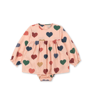 Konges Sløjd ELIN Romper aus gekräuseltem Seersucker-Stoff in Rosa mit Herzchen, GOTS-zertifizierte Bio-Baumwolle, mit Druckknöpfen und Raffungen an den Ärmeln.