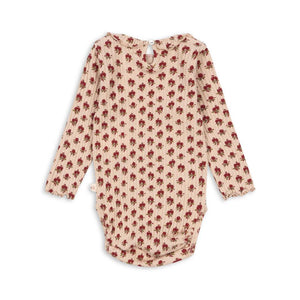 Konges Sløjd Body Nola in Ruby Rose – langärmeliger Babybody aus Bio-Baumwolle mit Rosenprint und Rüschen an den Schultern.